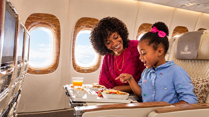 Mother and daughter enjoying a meal on an Emirates flight.