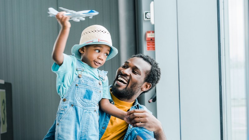 A father and a son playing a toy plane at the airport