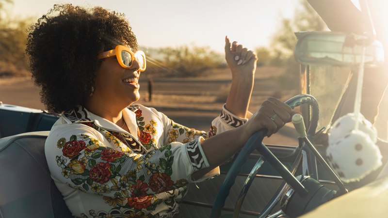 A joyful woman driving a car