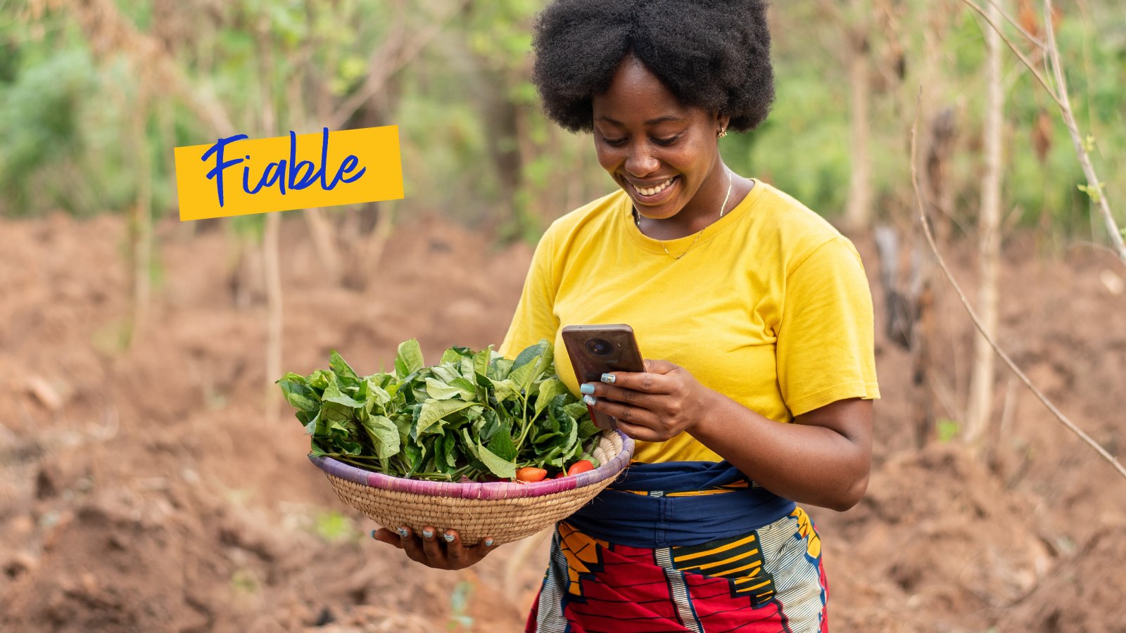 Femme sourit, tient panier, utilise le téléphone. Fiable