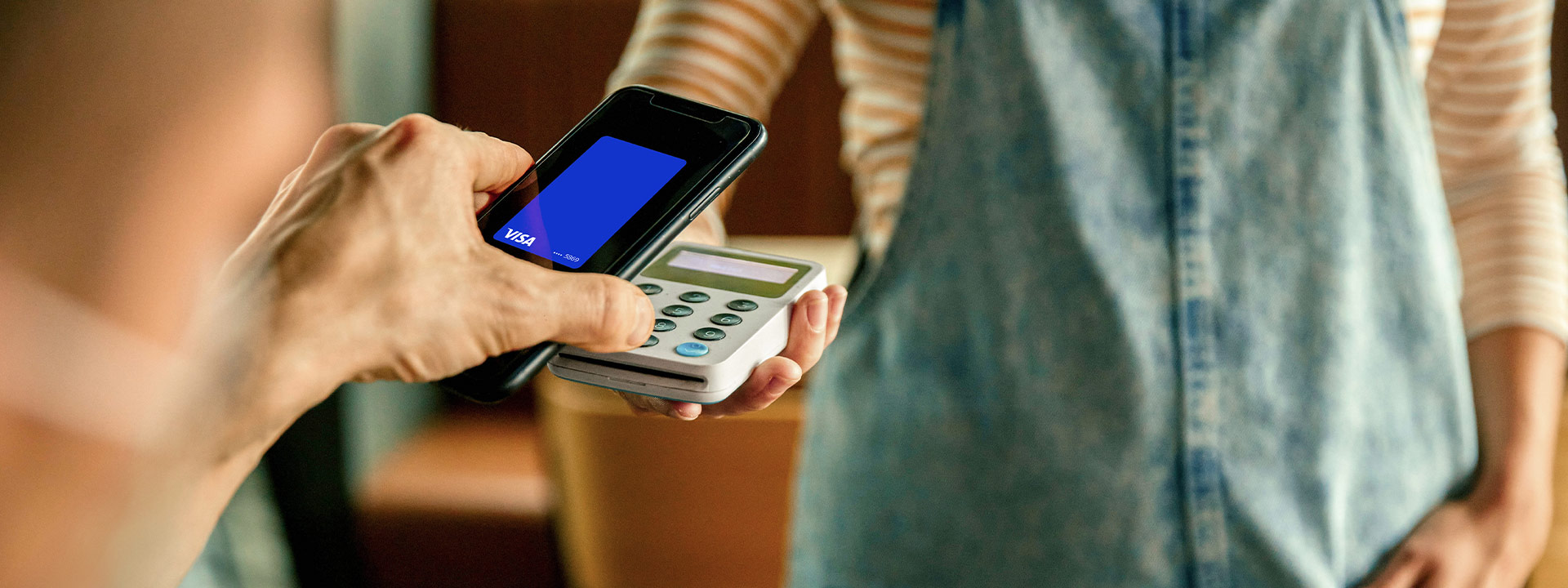 Using phone showing Visa-branded card to pay.