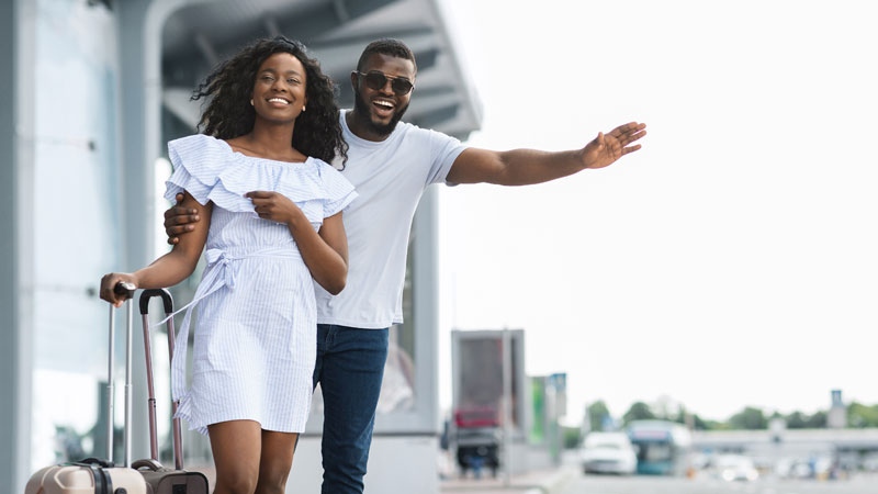 Smiling man and woman with suitcases at the airport