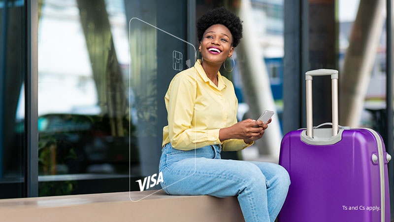 A woman sitting with a phone near her suitcase